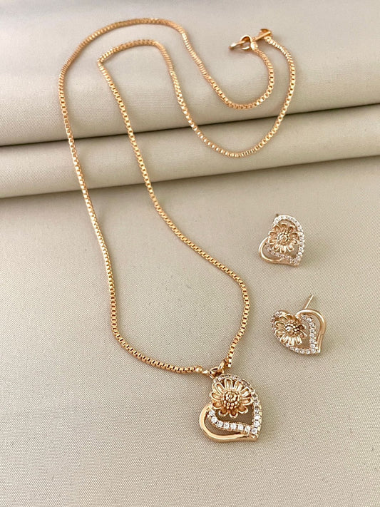 Gold necklace and earrings set with heart-shaped pendants and floral designs.