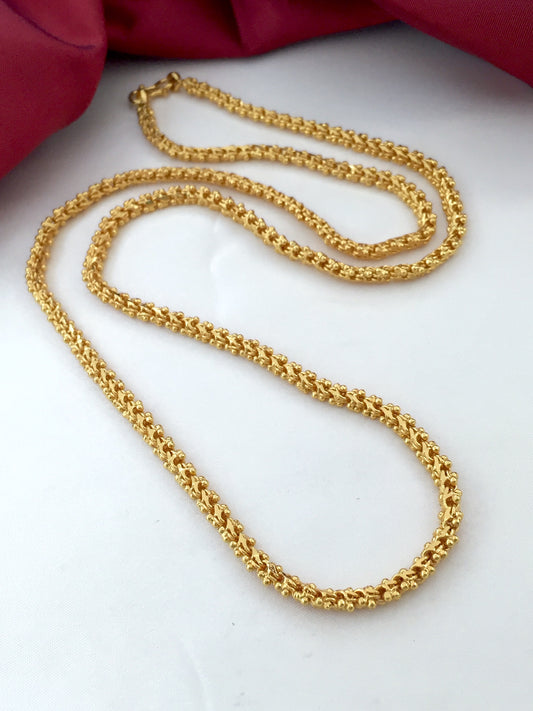 A gold chain necklace with intricate detailing.