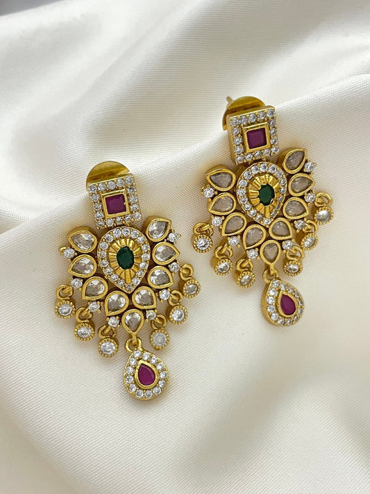 Gold-toned chandelier earrings with American diamonds, featuring green and pink gemstones.