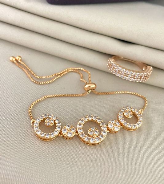 Gold bracelet with circular diamond accents and a matching gold ring with diamond embellishments.